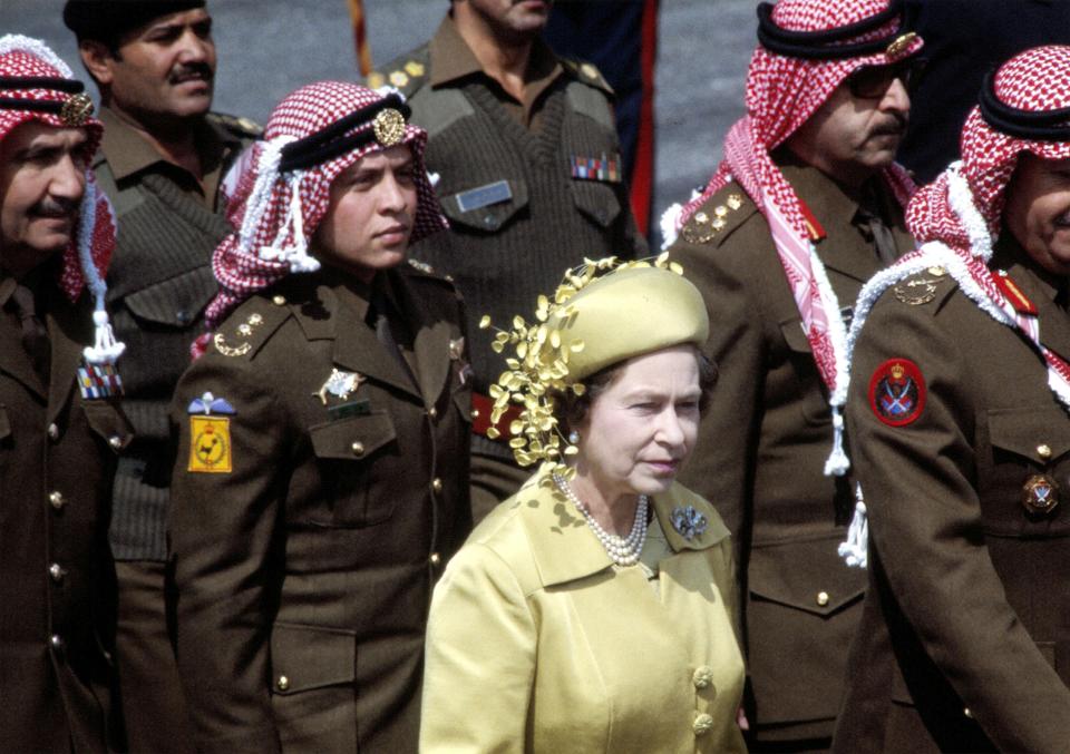 FILE - Britain's Queen Elizabeth II, stands in front of Abdullah, who would later become king, with members of the Jordanian Army on her arrival for a State Visit, in Amman, Jordan, March 27 1984. Not long after Queen Elizabeth II inherited her throne, large swaths of the world broke free from British control. Yet today after her death, British-installed monarchies still reign over millions across the Middle East. (AP Photo/Saade, File)