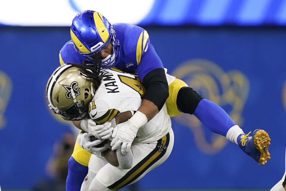 Los Angeles Rams defensive tackle Aaron Donald, top, tackles New Orleans Saints running back Alvin Kamara during the first half of an NFL football game Thursday, Dec. 21, 2023, in Inglewood, Calif. (AP Photo/Ryan Sun)