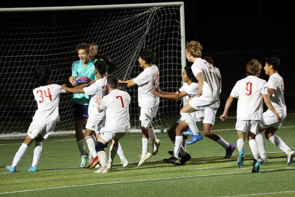 Paul Laurence Dunbar goalkeeper Mason Feddock is swarmed by his teammates as the Bulldogs celebrate winning the KHSAA boys’ soccer state championship last fall. Dunbar enters 2023 seeking its third consecutive state title.