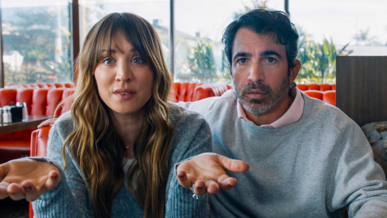  Kaley Cuoco and Chris Messina sitting in a diner with expressive faces in Based on a True Story. 