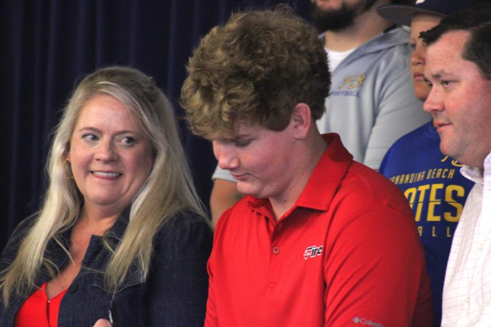Flanked by his parents, Melinda and Jeff Blackard, Fernandina Beach senior Nolan Blackard signs a national letter of intent to play college football at Southeastern University during a college athletic signing ceremony on May 1, 2024. The football offensive lineman was born with one hand. [Clayton Freeman/Florida Times-Union]