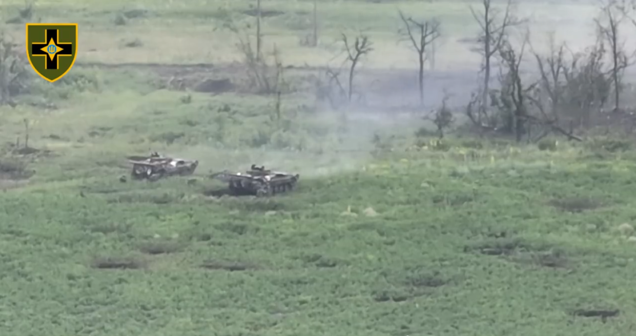 ukrainian infantry from 28th mechanized brigade dismount from their bmp 2 vehicle's rear ramps while the turret gunners continue to strafe russian trenches in the tree line