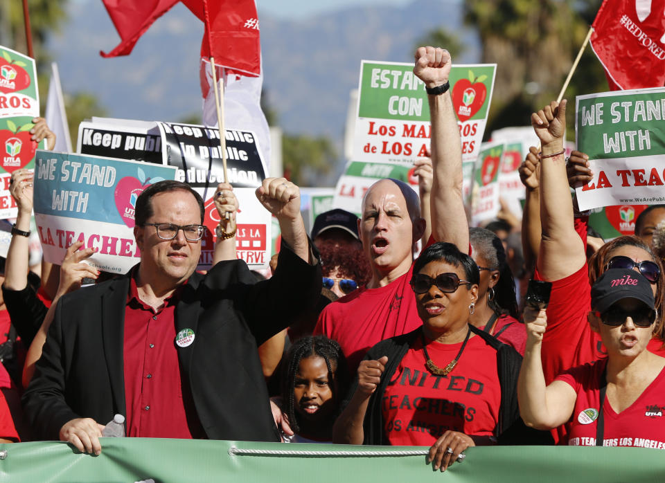 In this Saturday, Dec. 15, 2018, photo, United Teachers Los Angeles, UTLA president, Alex Caputo-Pearl, left, joins teachers at a rally next to the Broad Museum downtown Los Angeles. Teachers in the nation's second-largest school district will go on strike next month if there's no settlement of its long-running contract dispute, union leaders said Wednesday, Dec. 19. The announcement by UTLA threatens the first strike against the Los Angeles Unified School District in nearly 30 years and follows about 20 months of negotiations. (AP Photo/Damian Dovarganes)