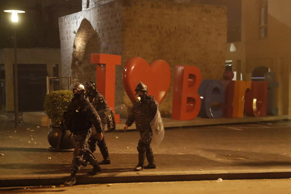 Riot policemen advance as they push back the anti-government protesters, during a protest against the new government, in downtown Beirut, Lebanon, Wednesday, Jan. 22, 2020. Lebanon's new government, made up of members nominated by the Shiite group Hezbollah and its allies got down to business Wednesday, a day after it was formed. Questions arose immediately about its ability to halt a spiral of economic and political collapse. (AP Photo/Hussein Malla)