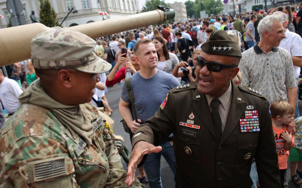 General Darryl Williams, the new commanding general of United States Army Europe and Africa, second right, greets with US soldier during a picnic marking the Polish Army Day in Warsaw - AP Photo/Michal Dyjuk