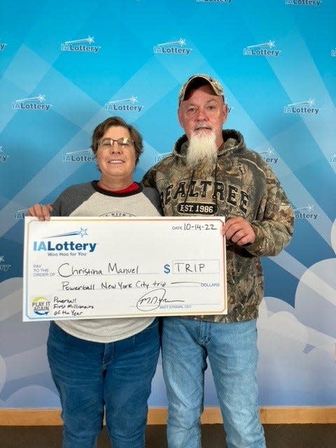 Chris Manuel with husband Randy, holding a check from the Iowa Lottery for their New York City trip.
