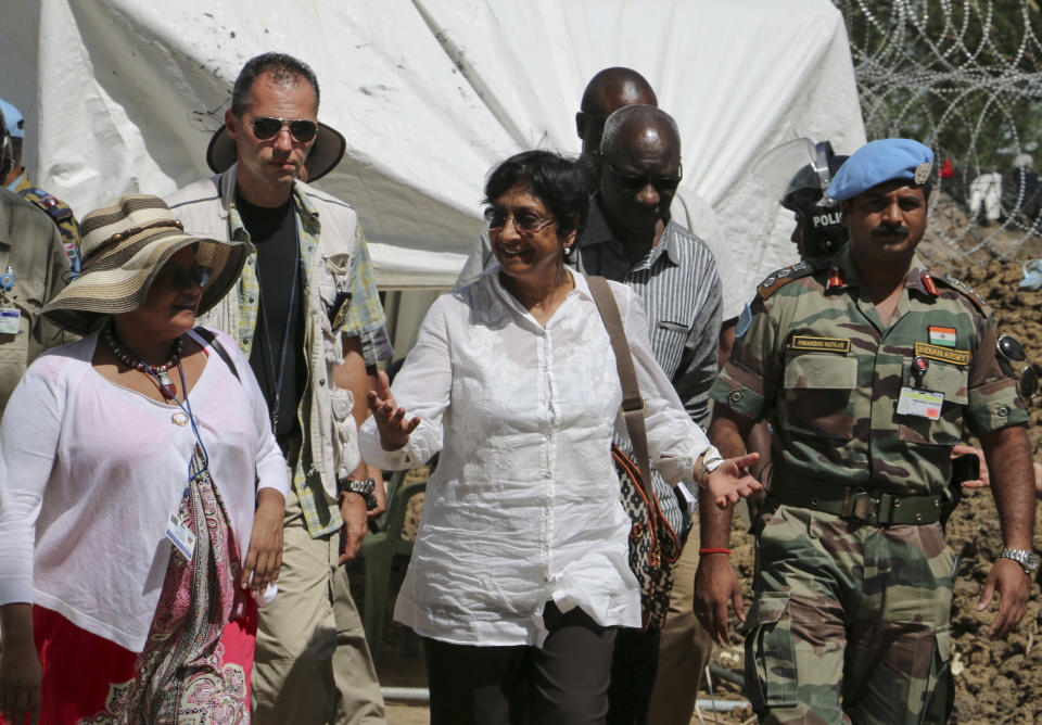 In this photo taken Tuesday, April 29, 2014 and released by the United Nations Mission in South Sudan (UNMISS) on Wednesday, April 30, 2014, United Nations High Commissioner for Human Rights Navi Pillay, center, visits an undisclosed location in South Sudan. The U.N.'s top official for human rights told a news conference in South Sudan's capital Juba on Wednesday that the country is on the verge of catastrophe because of a deadly mix of recrimination, hate speech and revenge killings since December and that she is appalled by the apparent lack of concern by leaders in South Sudan over the risk of a potential famine. (AP Photo/UNMISS)