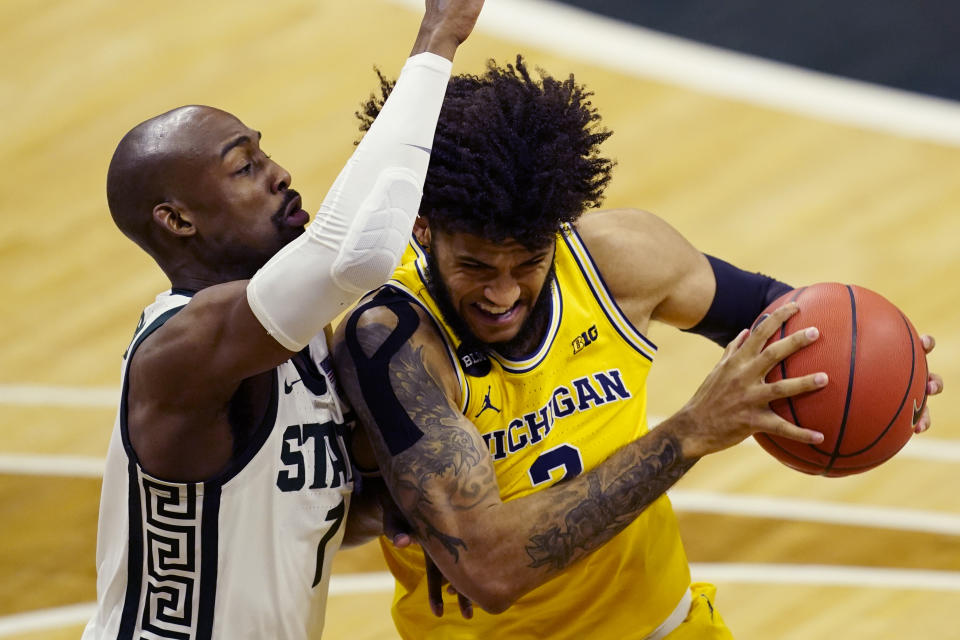 Michigan forward Isaiah Livers (2) is defended by Michigan State guard Joshua Langford (1) during the first half of an NCAA college basketball game, Sunday, March 7, 2021, in East Lansing, Mich. (AP Photo/Carlos Osorio)