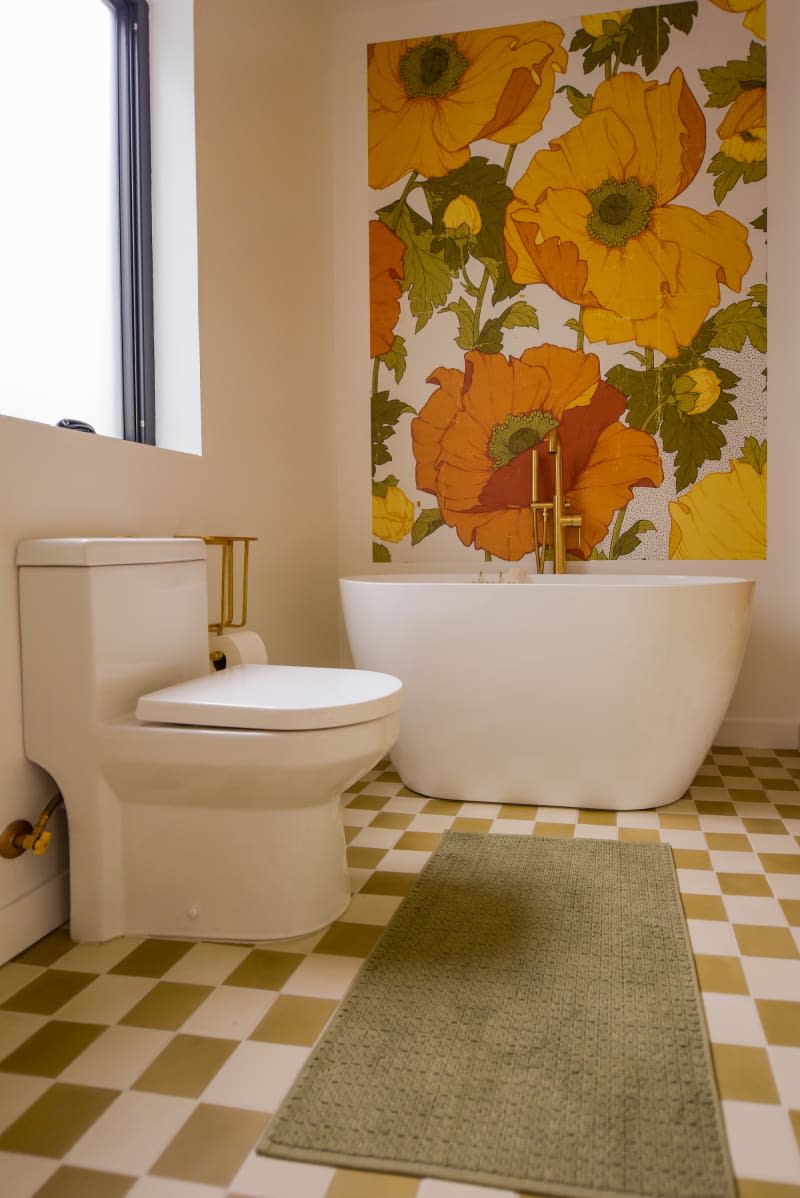 Bathroom with graphic floral wallpaper and checkerboard flooring.