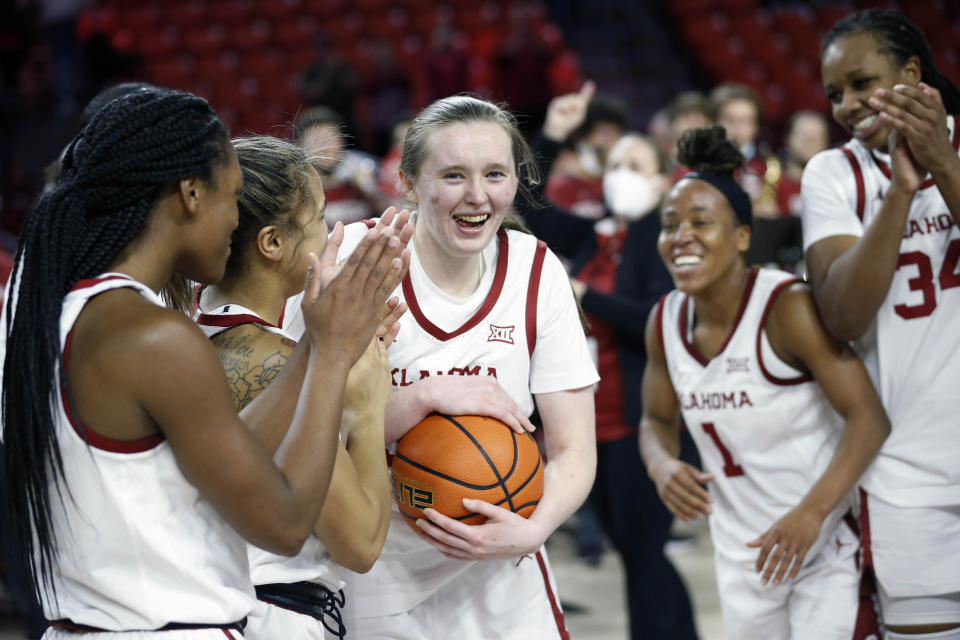 FILE - Oklahoma guard Taylor Robertson (30), center, celebrates with her teammates, Kennady Tucker, left, Kelbie Washington, Nevaeh Tot, and Liz Scott after an NCAA college basketball game against Baylor Wednesday, Jan. 12, 2022, in Norman, Okla. Taylor Robertson broke the Big 12 record for three-pointers. Oklahoma made the biggest jump in The Associated Press women’s college basketball poll, Monday, Jan. 17, 2022, climbing nine spots to 14th.(AP Photo/Garett Fisbeck, File)