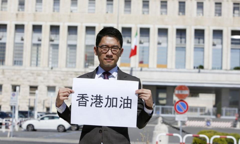 Exiled Hong Kong’s activist Nathan Law holds a sign reading in Chinese “Go Hong Kong” as he meets the press outside of the Italian Foreign Ministry.