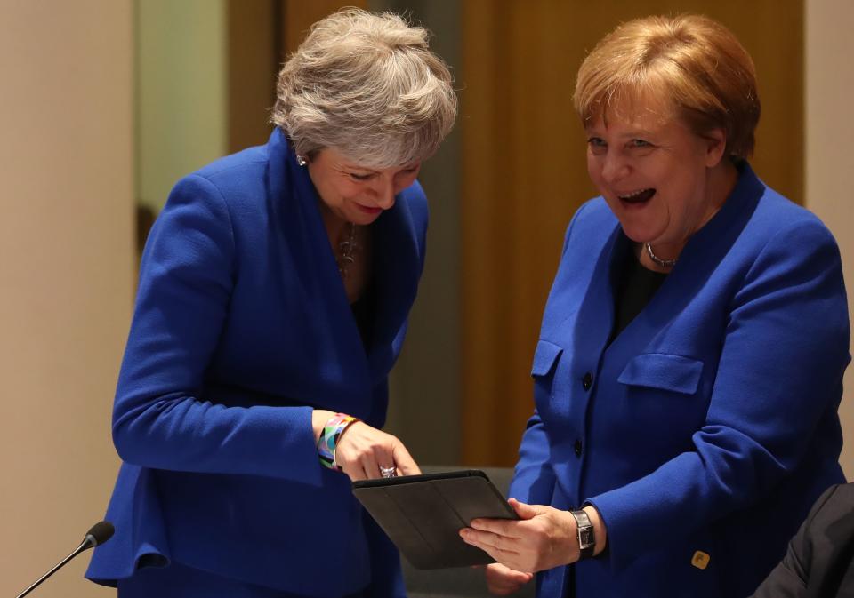 Britain's Prime minister Theresa May, left, and Germany's Chancellor Angela Merkel look at a tablet ahead of a European Council meeting on Brexit in Brussels on April 10, 2019.