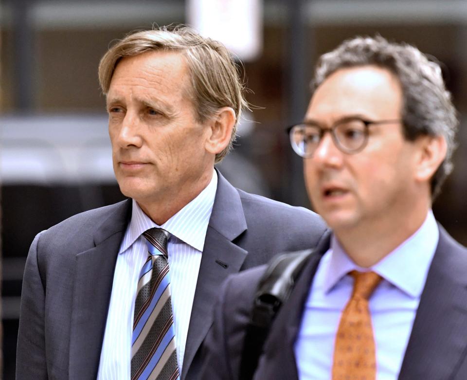 Jeffrey Bizzack, left, arrives at federal court with a member of his defense team, Wednesday July 24, 2019, in Boston where he is expected to plead guilty to charges for allegedly paying to get his son into the University of Southern California as a fake volleyball recruit. (AP Photo/Josh Reynolds) ORG XMIT: MACR103