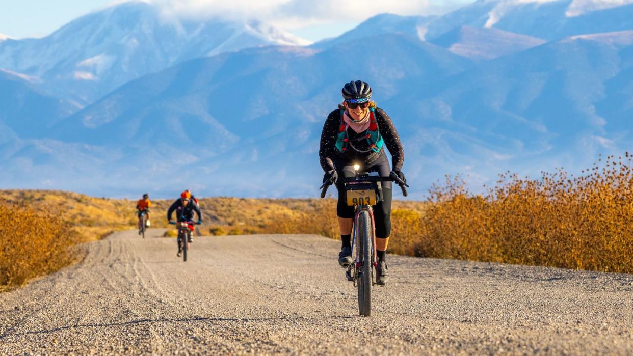 a group of people riding bikes on a dirt road