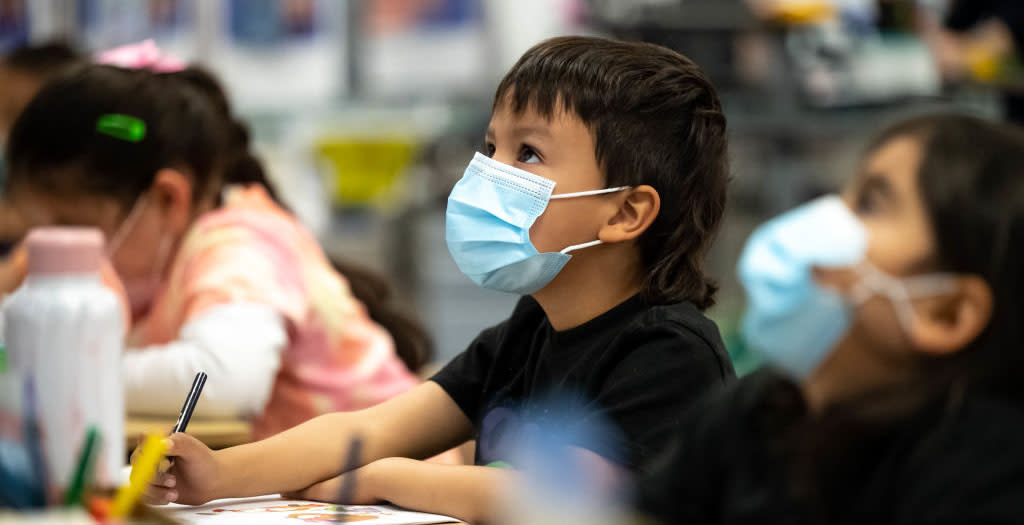 A photo of kindergarten students wearing masks in a classroom