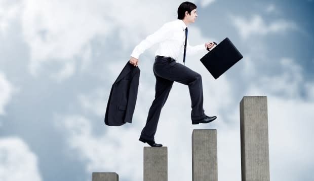 Young businessman climbing grey steps