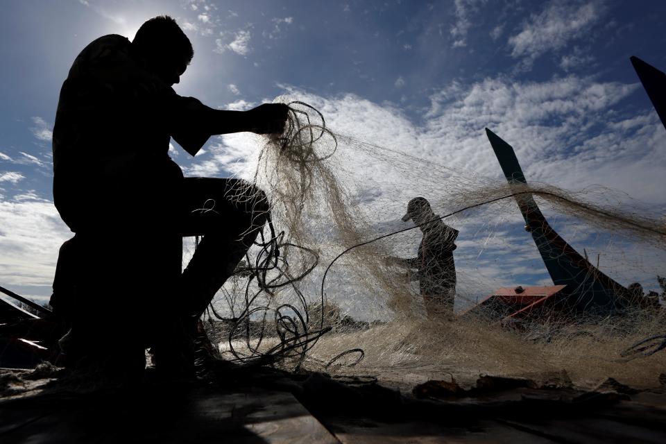 FOTO: Varios pescadores rescatan el pescado enredado a su regreso a puerto. EFE/ Hotli Simanjuntak