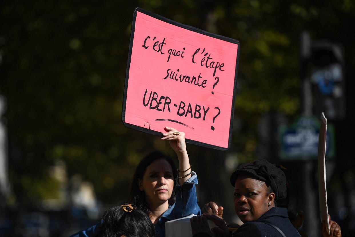 Une manifestante présente une banderole indiquant « Quelle est l’étape suivante ? Uber-Bébé ? » lors d’une manifestation organisée par des éducateurs de crèches à Paris, le 6 octobre 2022.