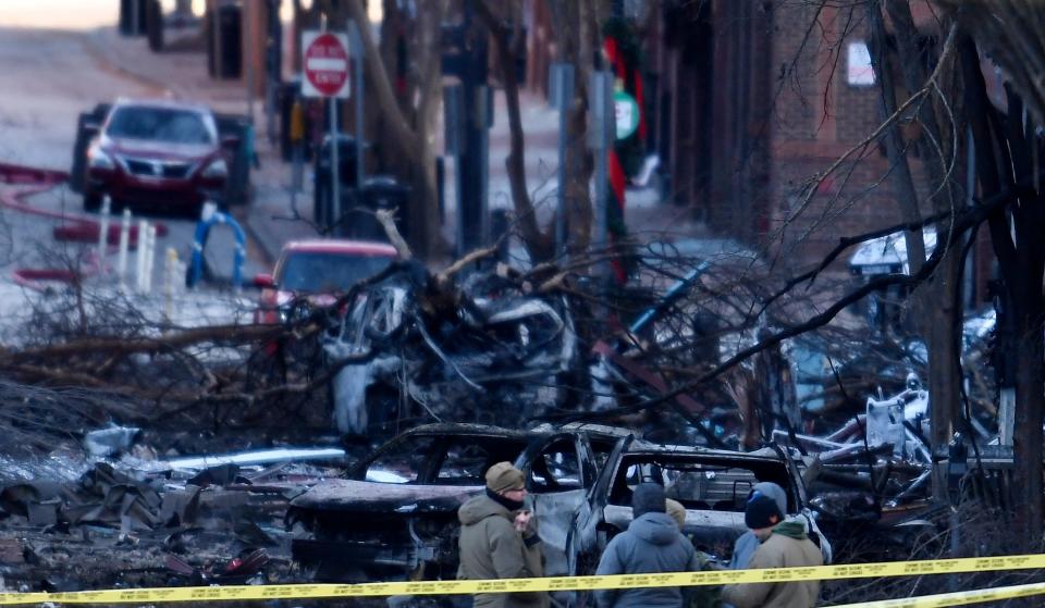 Investigators walk through the scene of the explosion on Second Avenue on Friday, Dec. 25, 2020 in Nashville, Tenn.