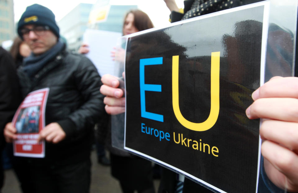 Ukrainian protesters stand outside the European Council building in Brussels, Thursday, Feb. 20, 2014. The 28-nation European Union is holding an emergency meeting on Ukraine, to consider sanctions against those behind the violence. (AP Photo/Yves Logghe)