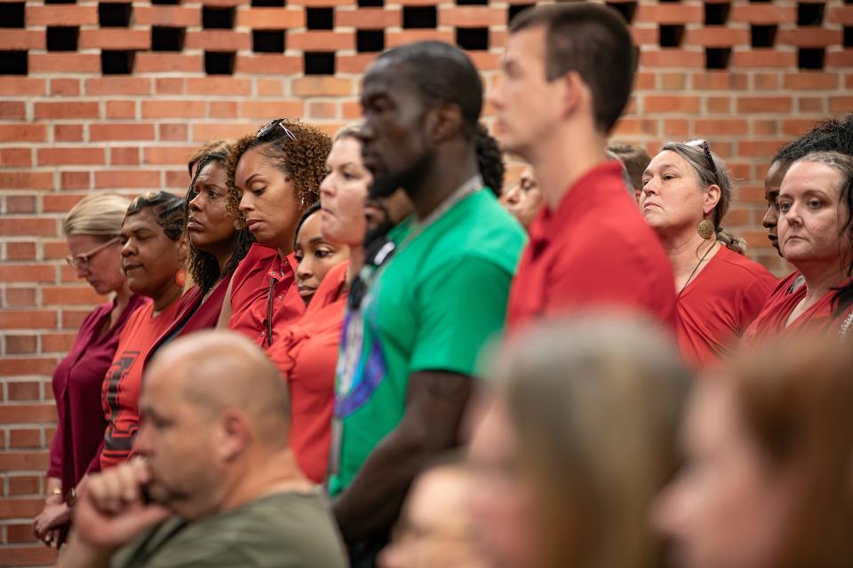 Concerned elementary school principals wore red and stood during remarks by Hazelwood Elementary Principal Courtney Grace during a JCPS board meeting on Tuesday, May 7, 2024.