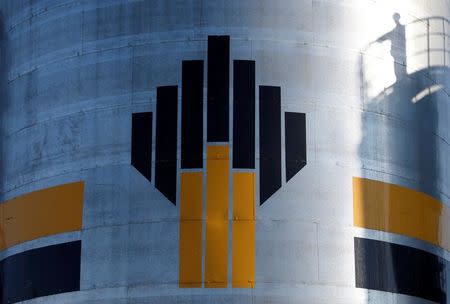 FILE PHOTO - The shadow of a worker is seen next to a logo of Russia's Rosneft oil company at the central processing facility of the Rosneft-owned Priobskoye oil field outside the West Siberian city of Nefteyugansk, Russia, August 4, 2016. REUTERS/Sergei Karpukhin/File Photo