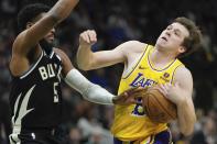 Milwaukee Bucks' Malik Beasley fouls Los Angeles Lakers' Austin Reaves during the first half of an NBA basketball game Tuesday, March 26, 2024, in Milwaukee. (AP Photo/Morry Gash)