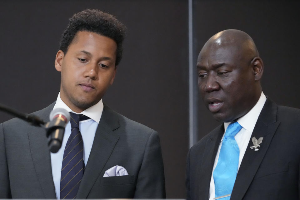 Former Northwestern quarterback Lloyd Yates, left, listens to attorney Ben Crump, right, at a news conference in Chicago, Monday, July 24, 2023. A Northwestern hazing scandal includes multiple sports, men and women, attorneys have said. (AP Photo/Nam Y. Huh)