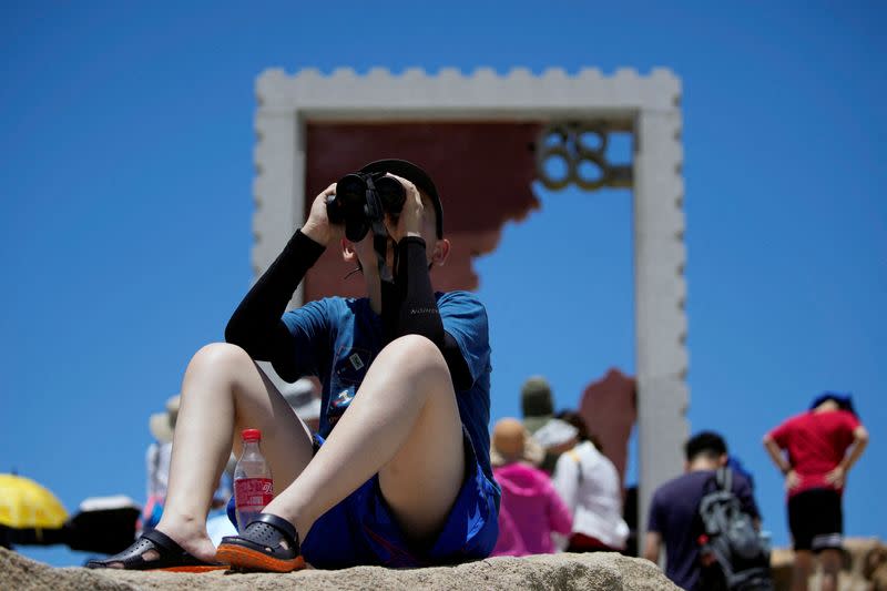 Un niño sostiene unos prismáticos en el punto panorámico de 68 millas náuticas, uno de los puntos más cercanos de China continental a la isla de Taiwán, en la isla Pingtan, provincia de Fujian, China