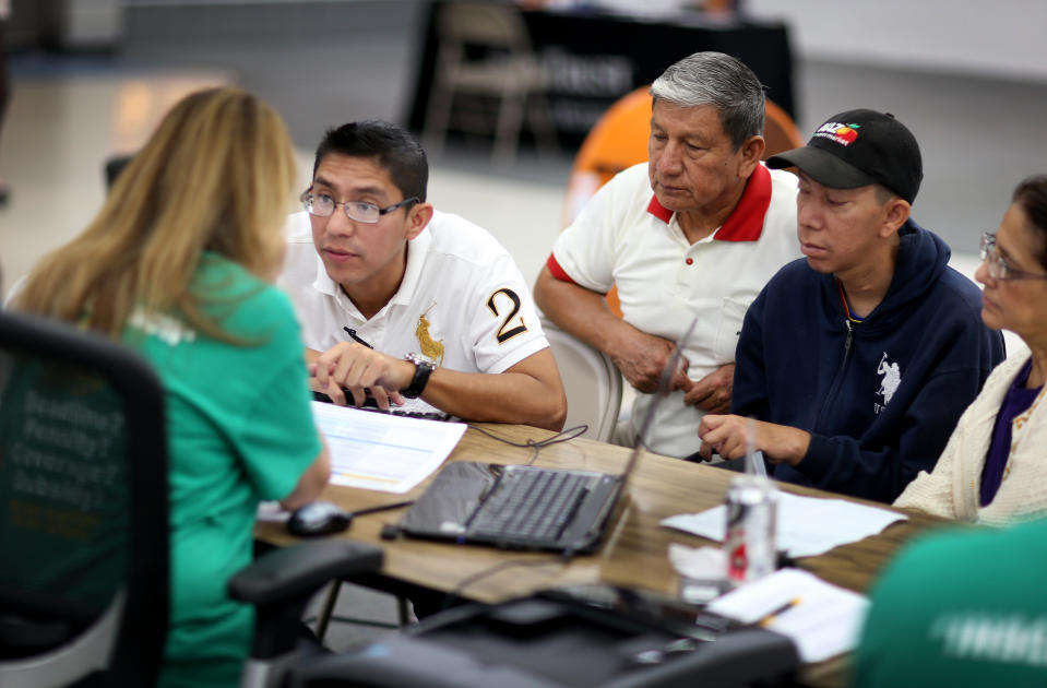 A group of Florida residents sit with an insurance agent as they try to purchase health insurance.