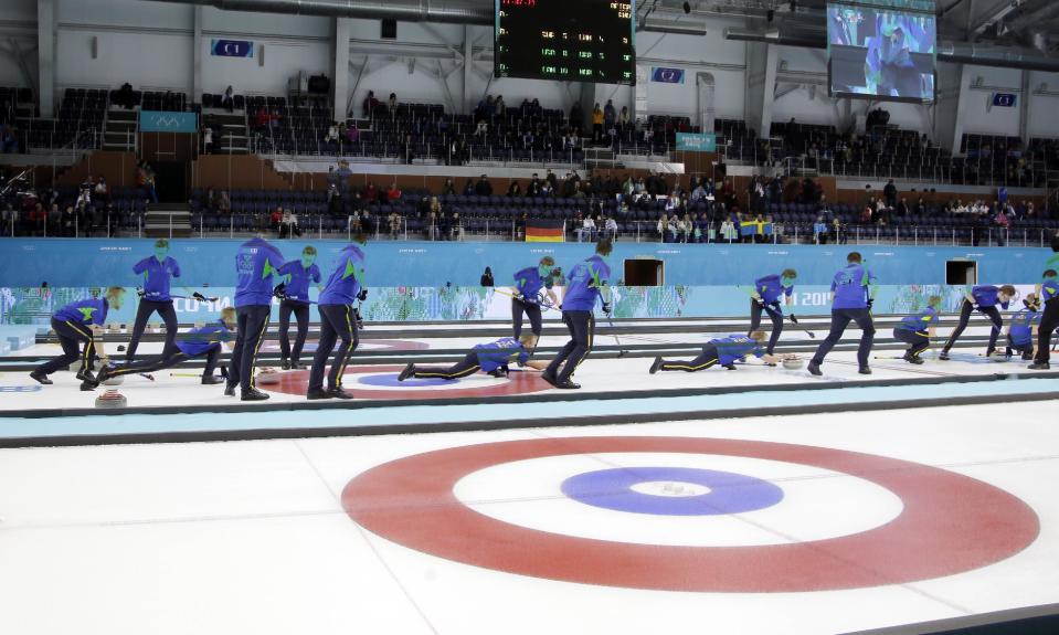 This multiple exposure photo shows the Sweden curling team throwing during a round robin session against China in the Ice Cube Curling Center at the 2014 Winter Olympics, Friday, Feb. 14, 2014, in Sochi, Russia. (AP Photo/Morry Gash)