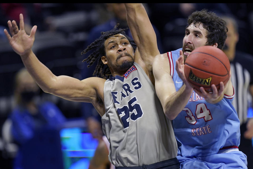 Lewis-Clark State forward Jake Albright (34) shoots while covered by Shawnee State forward Latavious Mitchell (25) during the first half of an NAIA basketball game in the finals of the national tournament in Kansas City, Mo., Tuesday, March 23, 2021. (AP Photo/Orlin Wagner)