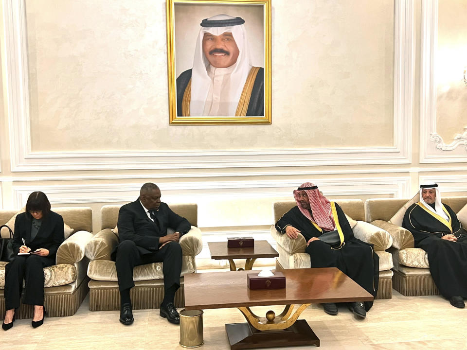 US Secretary Lloyd Austin, second left, pays his respects to Kuwait’s Defense Minister Ahmed AlFahad Alsabah and Foreign Minister Salem Abdallah Alsabah under a painting of the late Kuwaiti Emir Sheikh Nawaf Al Ahmad Al Sabah, in Kuwait City, Sunday, Dec, 17, 2023. Kuwait’s ruling emir died at the age of 86, State television reported on Saturday. (AP Photo/Tara Copp)