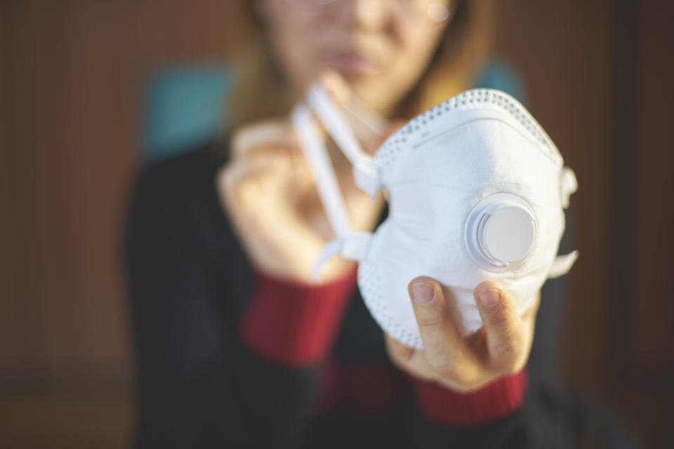 Una mujer sostiene una mascarilla (Foto:Getty)