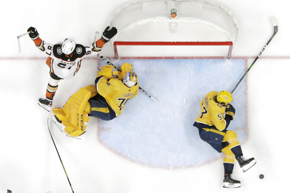 Anaheim Ducks left wing Rickard Rakell (67), of Sweden, celebrates after scoring against Nashville Predators goaltender Juuse Saros (74), of Finland, in the second period of an NHL hockey game Thursday, Jan. 16, 2020, in Nashville, Tenn. At right is Predators defenseman Dante Fabbro (57). (AP Photo/Mark Humphrey)