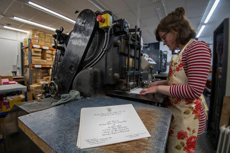 Lottie Small use the die stamping press at the workshop of Barnard and Westwood, who are printing the invitations for Britain's Prince Harry and Meghan Markle's wedding at Windsor Castle in May, London, Britain, March 22, 2018. Victoria Jones/Pool via Reuters