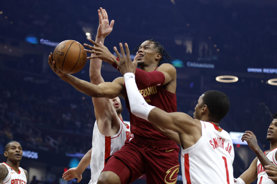 Cleveland Cavaliers forward Isaac Okoro, center, shoots against Houston Rockets forward Jabari Smith Jr. (1) and center Alperen Sengun during the first half of an NBA basketball game, Sunday, March 26, 2023, in Cleveland. (AP Photo/Ron Schwane)