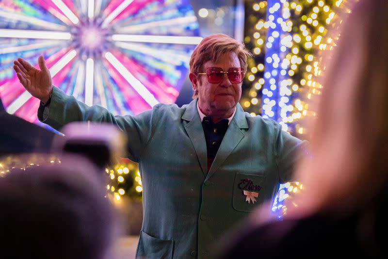 FILE PHOTO: Singer Sir Elton John poses for photos after a performance at an event to unveil the 2022 holiday windows displays at Saks 5th Avenue department store in New York City