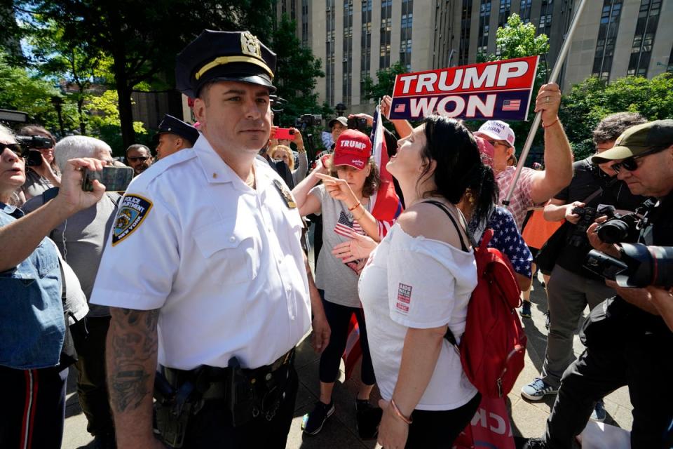 However, several large police agencies such as the New York City police and Los Angeles police do not report to the FBI system. Pictured:  A New York City Police Department officer looks on as Trump supporters gather outside of Manhattan Criminal Court (AFP via Getty Images)