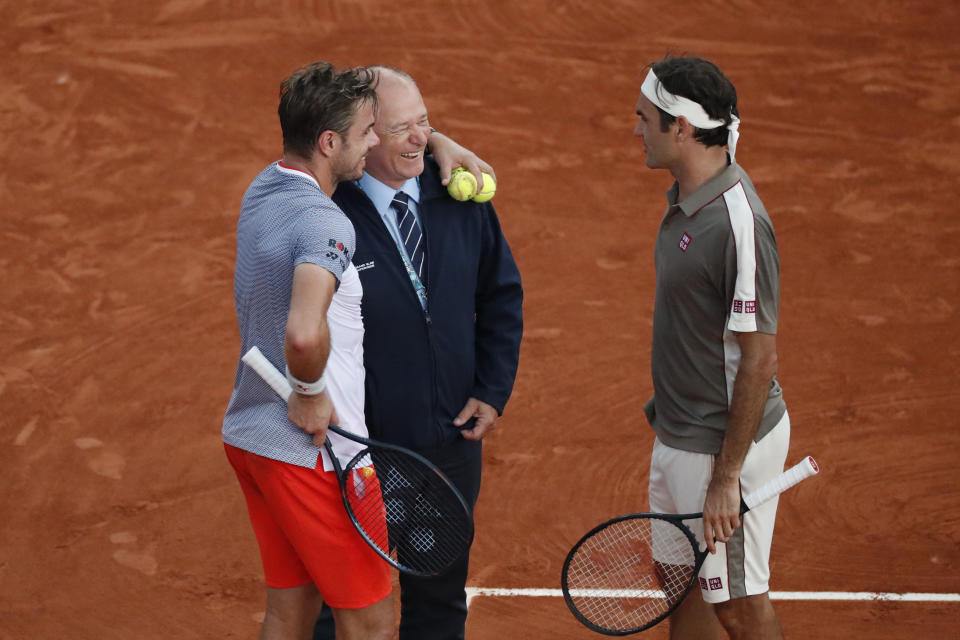 Switzerland's Roger Federer, right, and Switzerland's Stan Wawrinka, left, joke, during an interruption of their quarterfinal match of the French Open tennis tournament because of the rain at the Roland Garros stadium in Paris, Tuesday, June 4, 2019. (AP Photo/Jean-Francois Badias)