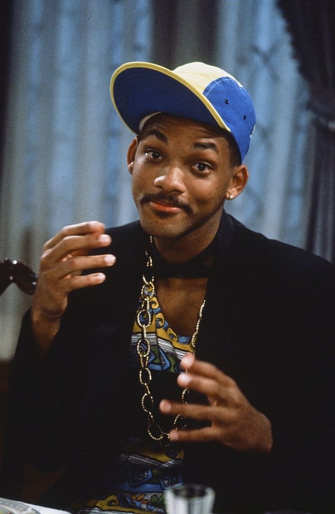 closeup of will making a face at the camera wearing gold necklaces and a hat