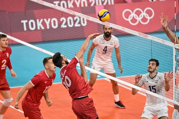 Canada's Ryan Sclater hits the ball in the men's preliminary round pool A volleyball match between Canada and Iran on Wednesday in Tokyo. (Andrej Isakovic/AFP via Getty Images - image credit)