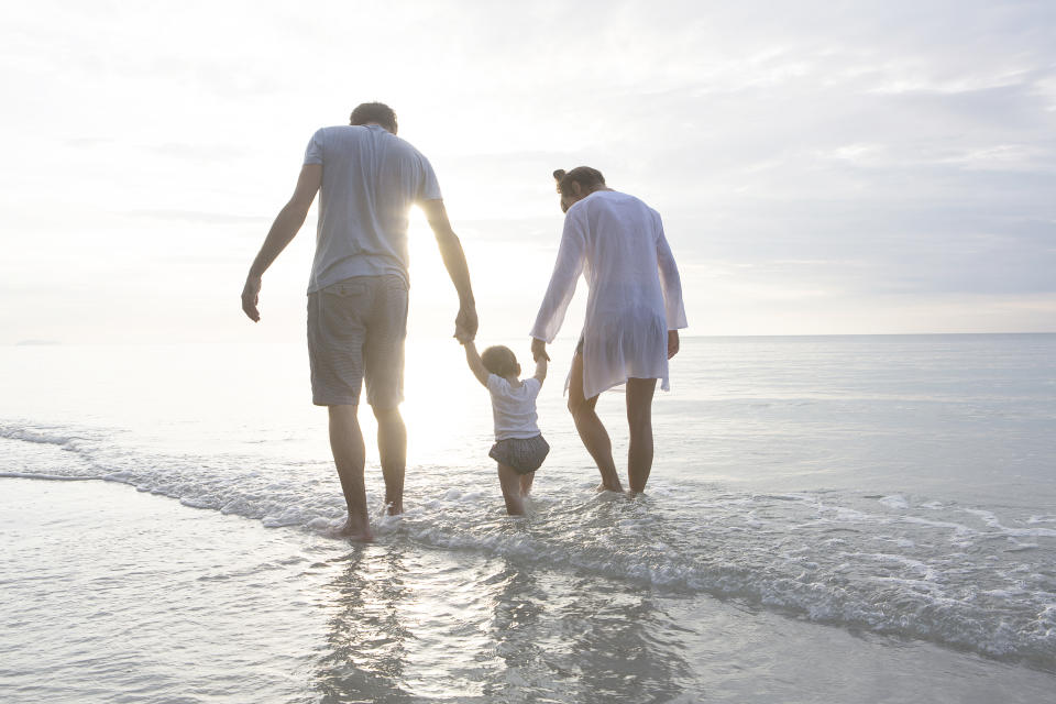 a young family walking on the beach 