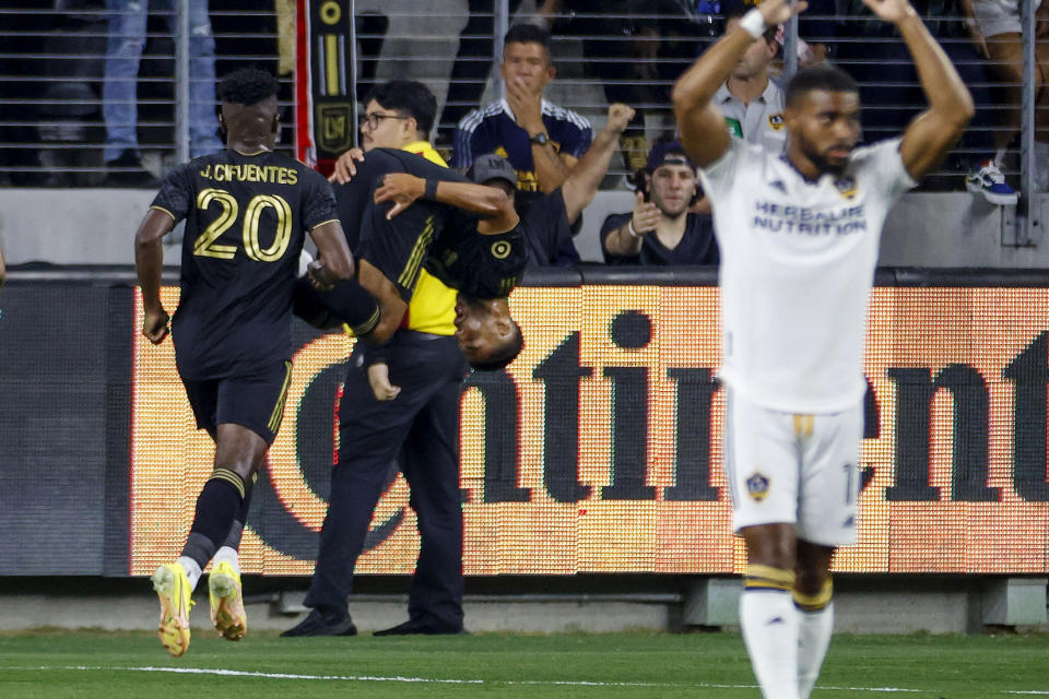 Los Angeles FC forward Denis Bouanga, center, flips in the air as he celebrates after scoring against the LA Galaxy during the first half of an MLS playoff soccer match Thursday, Oct. 20, 2022, in Los Angeles. (AP Photo/Ringo H.W. Chiu)