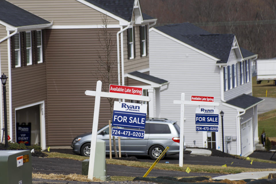 In this March 18, 2020 photo, model homes and for sale signs line the streets as construction continues at a housing plan in Zelienople, Pa. Would-be home sellers and buyers in the United States as well as in Europe are caught in the grip of a pandemic that has upended the housing market just as it was entering the busy spring season. Shutdown orders have halted open houses and complicated property viewings. (AP Photo/Keith Srakocic)