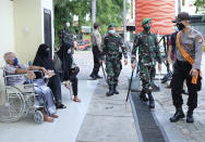 Police officers and soldiers who are stationed at Bhayangkara Hospital following an incident where mob forcefully took the body of a man who presumably died of COVID-19 patrol the hospital compound, in Makassar, South Sulawesi, Indonesia, Sunday, June 21, 2020. As Indonesia’s virus death toll rises, the world’s most populous Muslim country finds itself at odds with protocols put in place by the government to handle the bodies of victims of the pandemic. This has led to increasing incidents of bodies being taken from hospitals, rejection of COVID-19 health and safety procedures, and what some experts say is a lack of communication from the government. (AP Photo/Masyudi Syachban Firmansyah)