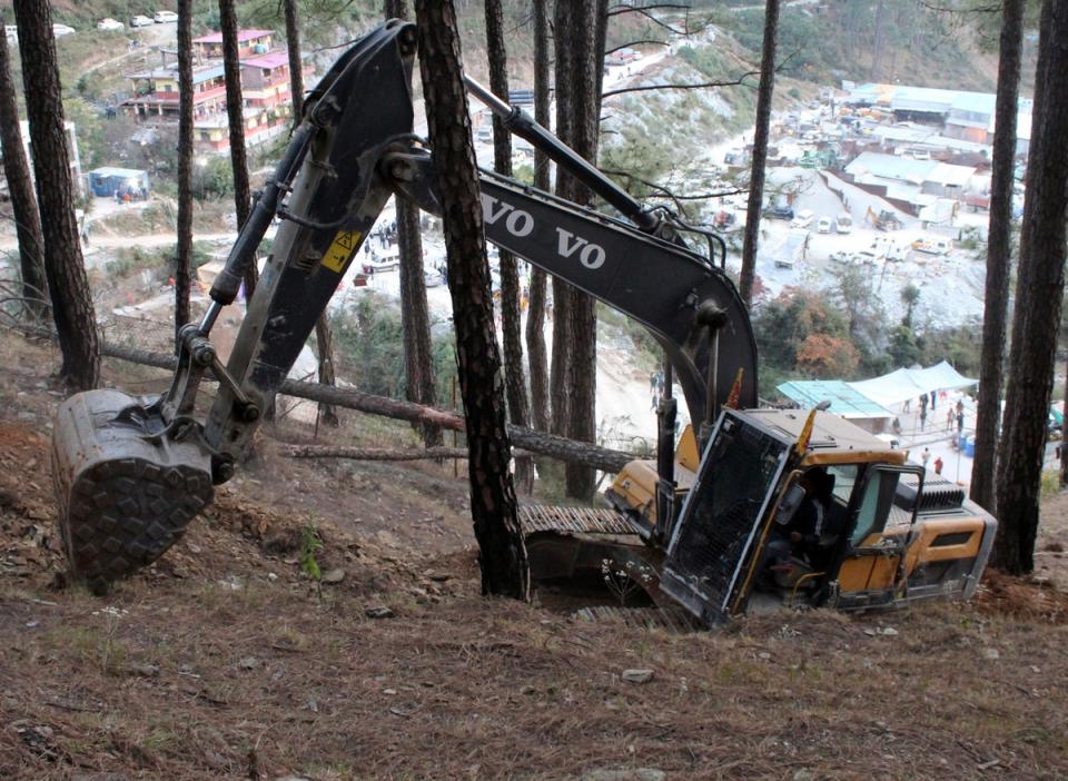 An earth-mover makes a vertical drill on the top of a mountain where a tunnel that collapsed in Uttarakhand state, India, Saturday, 18 Nov 2023. (Copyright 2023 The Associated Press. All rights reserved.)