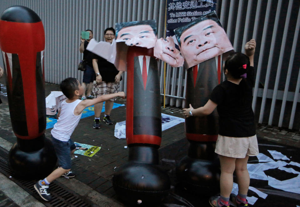 <p>Children hit cardboard boxes with photos of former Hong Kong Chief Executive Leung Chun-ying as protesters attend the annual pro-democracy protest in Hong Kong, Saturday, July 1, 2017. (Photo: Kin Cheung/AP) </p>