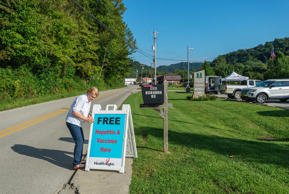 Brenda Parker, who works for West Virginia Health Right, sets up a sign advertising free hepatitis A vaccines as part of a mobile clinic that travels to rural areas around the state. (Photo: Craig Hudson for HuffPost)