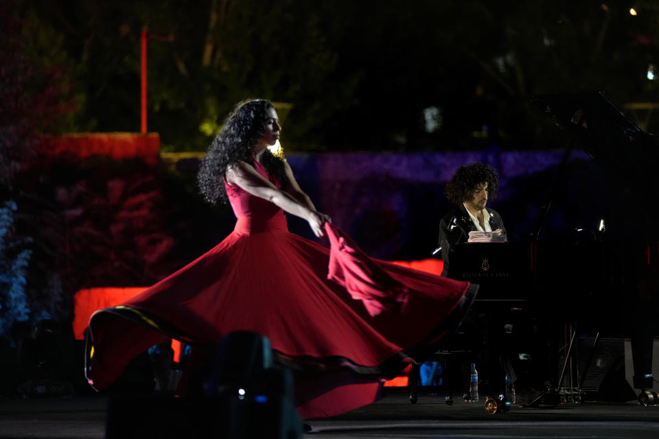 French Pianist Simon Ghraichy performs next to French-Iranian dancer Rana Gorgani during a concert in the ancient northeastern city of Baalbek, Lebanon, Sunday, July 17, 2022. Lebanon's renowned Baalbek Festival is back, held in front of a live audience for the first time in two years amid an ongoing economic meltdown. (AP Photo/Hassan Ammar)